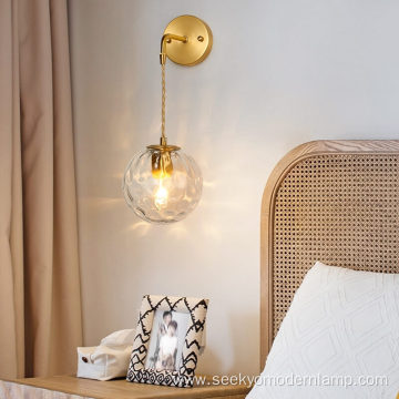 Copper wall lamp with suspended grain glass ball